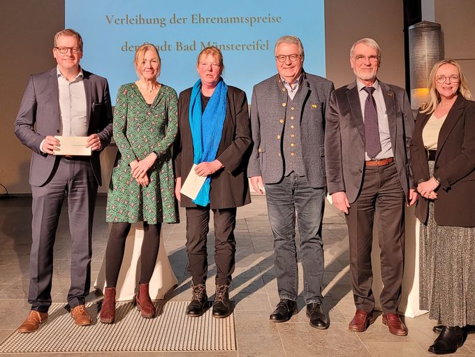 Den Ehrenamtspreis überreichte Bürgermeisterin Sabine Preiser-Marian (r.) an Peter Greven (v.l.), Waltraud Stening von der Bürgerstiftung, Sigrid Hien von der Dorfgemeinschaft Sasserath und Michael Nücken sowie Dr. Thomas Caro vom Verein Alter Münstereifeler. Sie stehen gemeinsam auf der Bühne.