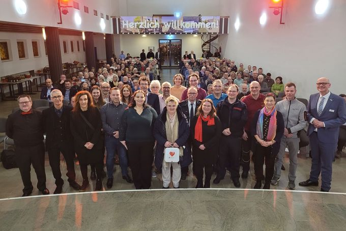 Gruppenbild der Ehrenamtspreisträger mit Publikum im Hintergrund.