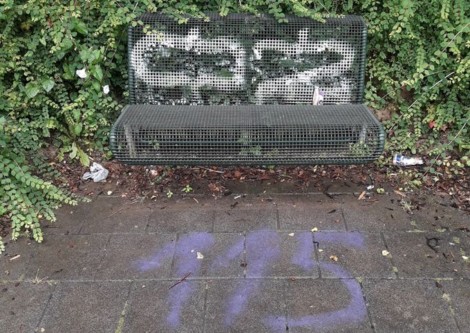 Das Bild zeigt eine mit Graffiti beschmierte Bank im Kurpark