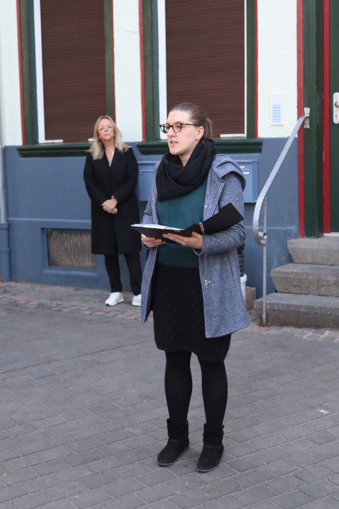Anna Rosemann liest aus einer Kladde vor. Im Hintergrund steht die Bürgermeisteirn.