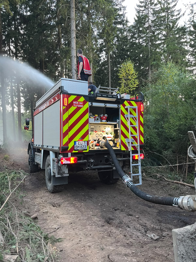 Tanklöschfahrzeug im Wald im Einsatz. blick von hinten.