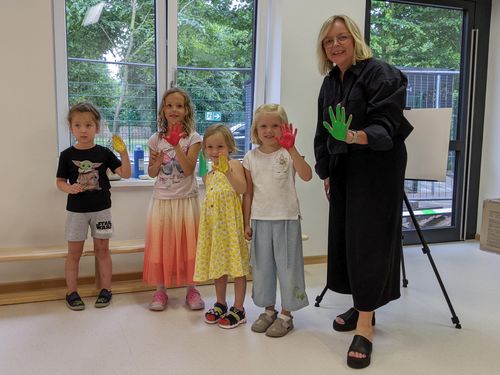 Bürgermeisterin Sabine Preiser-Marian und vier Kita-Kinder zeigen ihre bunte angemalten Hände