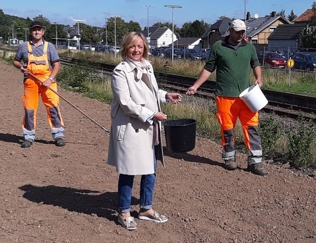Das Bild zeigt Bürgermeisterin Sabine Preiser-Marian mit zwei Bauhofarbeitern bei der Aussaat von Wildblumen